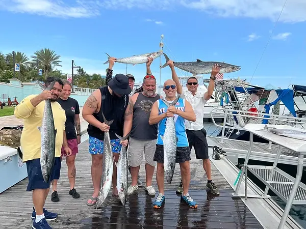 Veterans proudly showing fish caught during a sea trip